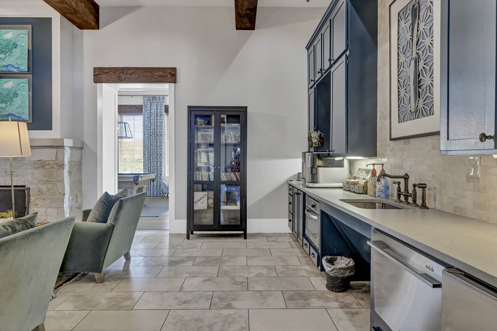 a kitchen with blue cabinets and a door to a living room