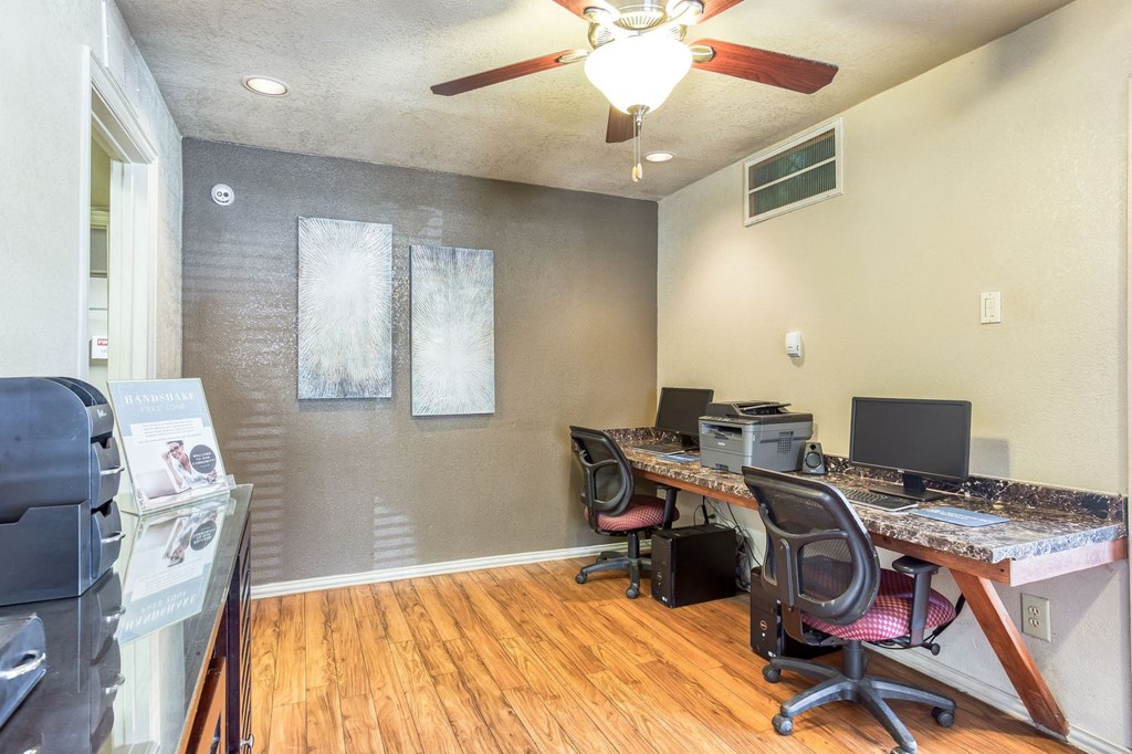 a home office with a desk and a ceiling fan