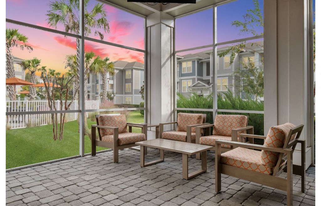 a patio with chairs and tables in front of a window