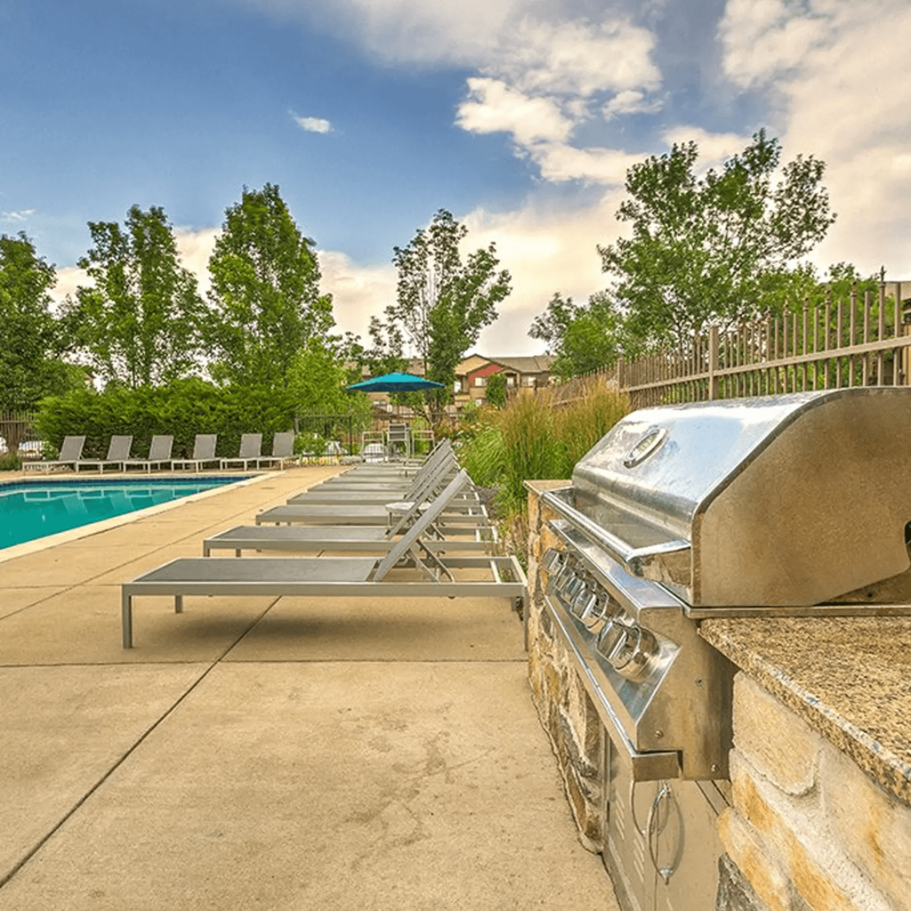 a backyard with a grill and a swimming pool