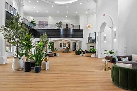 A spacious living room with a green sofa and a staircase.