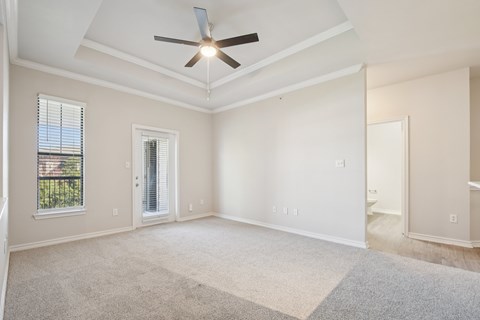 A room with a ceiling fan and a window with blinds.