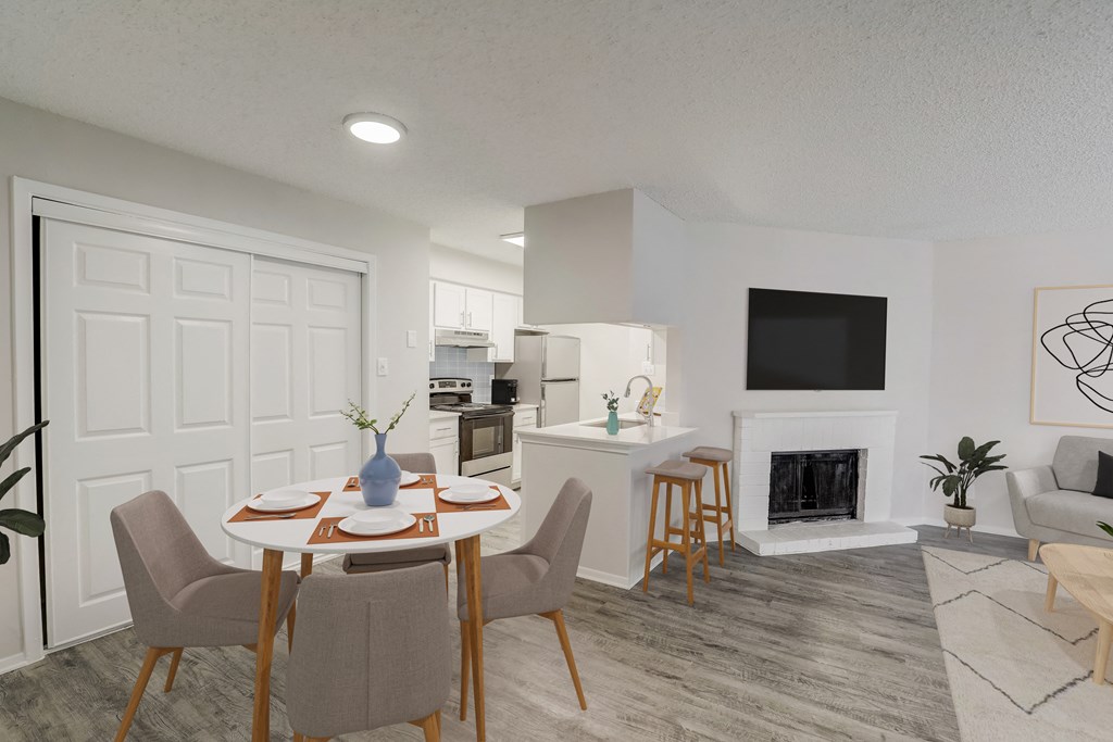 a living room and dining room with a table and chairs
