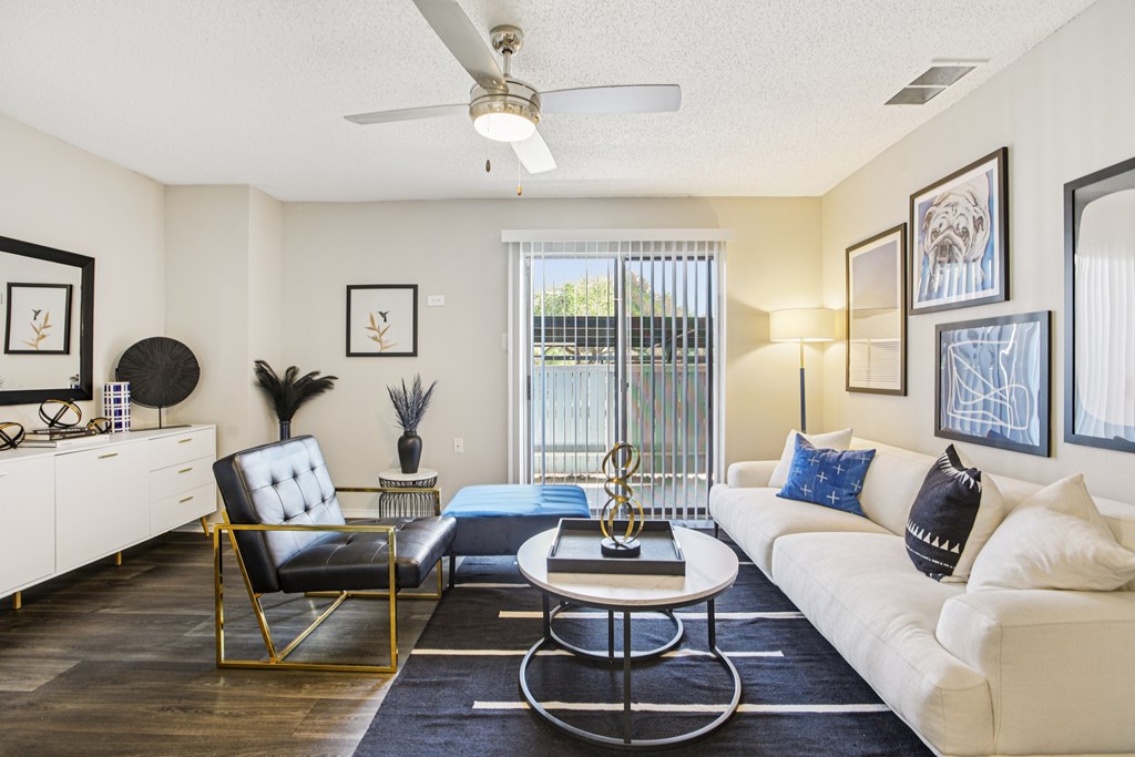 A living room with a white couch, a black chair, and a coffee table.
