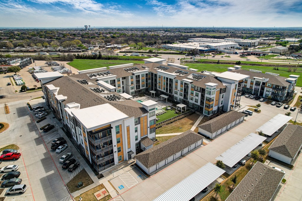 an aerial view of an apartment complex with cars parked in a parking lot
