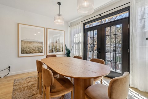 A dining room with a wooden table and chairs.