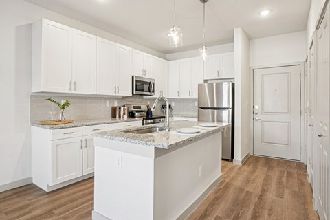 A kitchen with white cabinets and a central island.