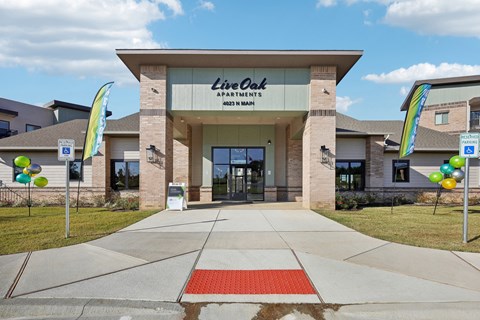 the front of the life coach apartments building with balloons