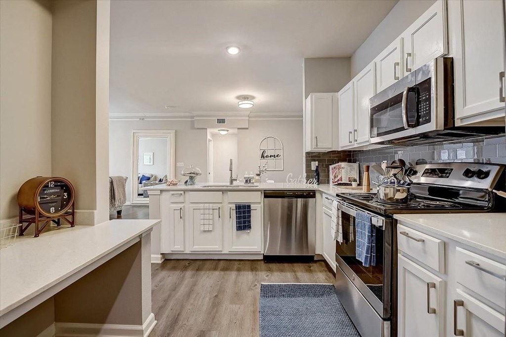 a kitchen with white cabinets and stainless steel appliances