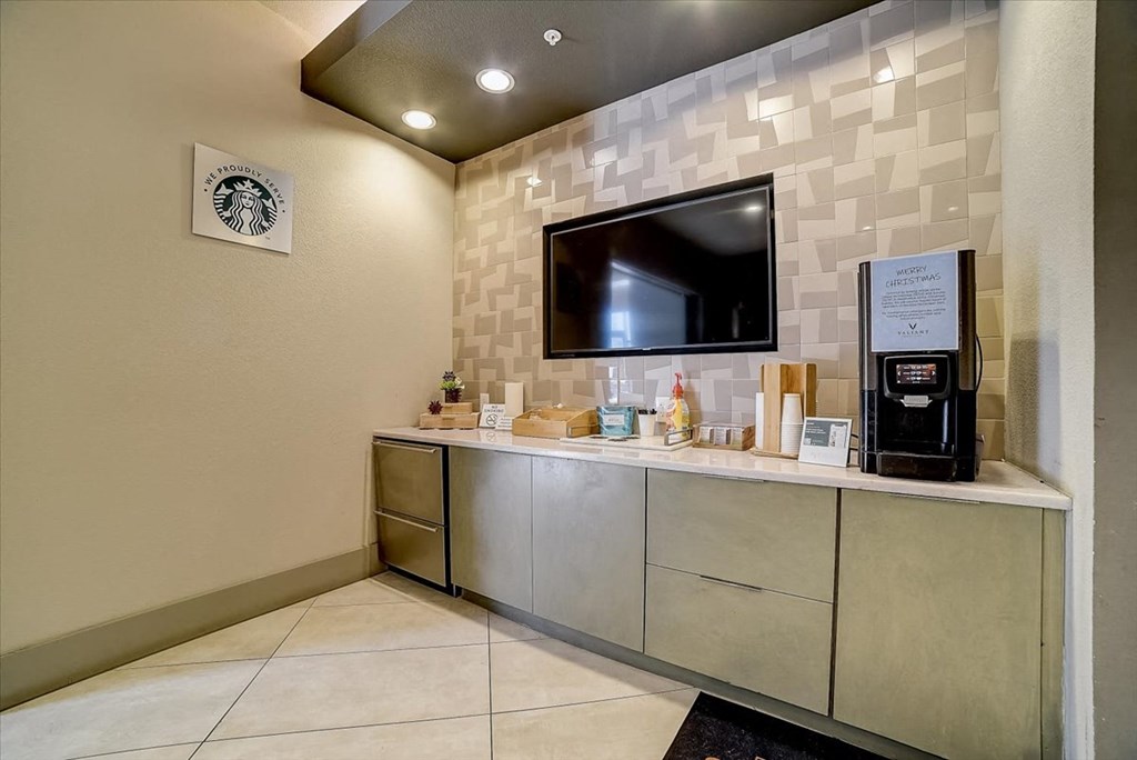 a lobby with a tv and a counter with a coffee machine