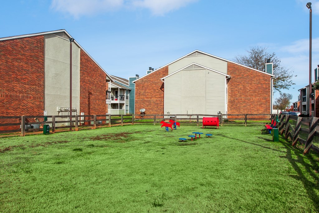 A green lawn in front of a red brick building.