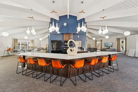 A large conference room with a long table and orange chairs.