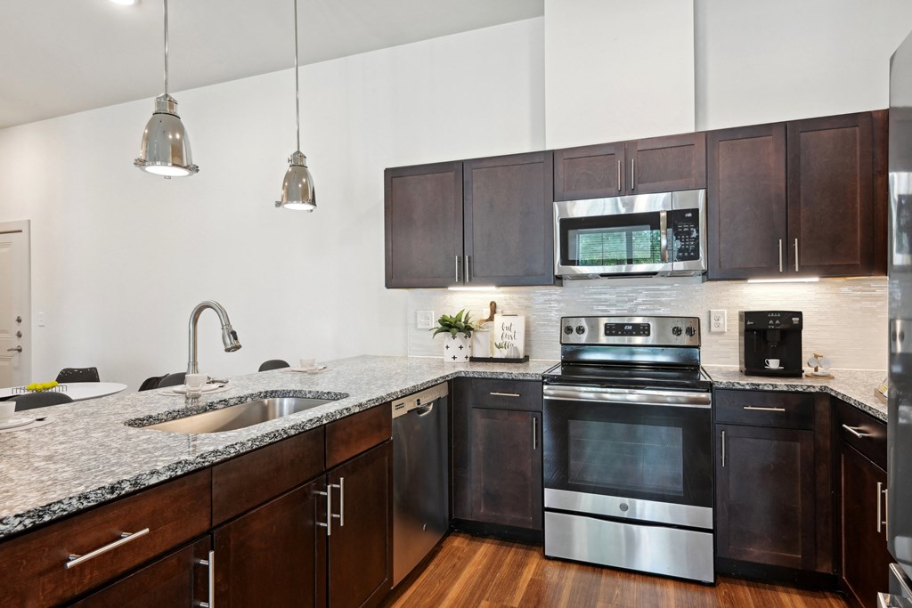 an apartment kitchen with stainless steel appliances and granite counter tops