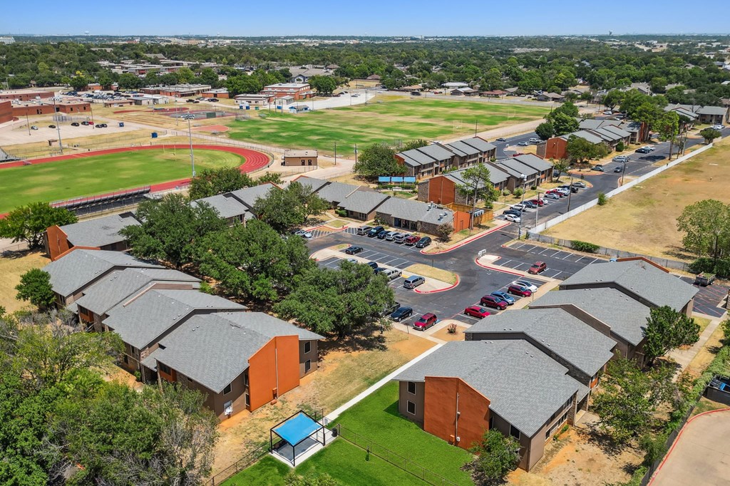an aerial view of a city with a baseball field in the background