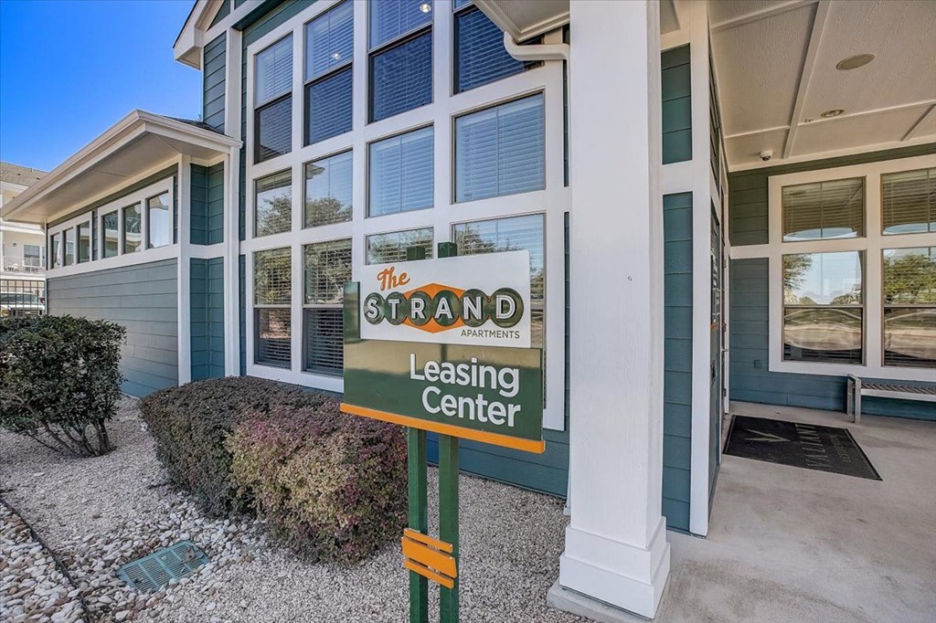 a green leasing center sign in front of a building