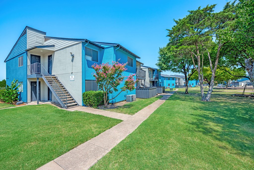 a row of colorful apartments with grass and trees