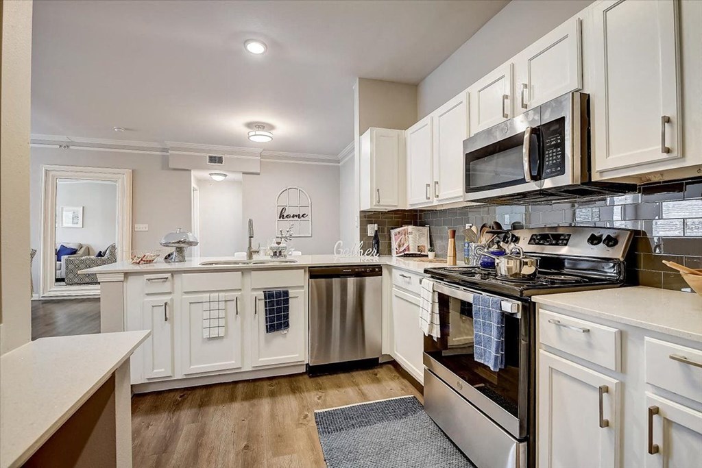 a kitchen with white cabinets and stainless steel appliances