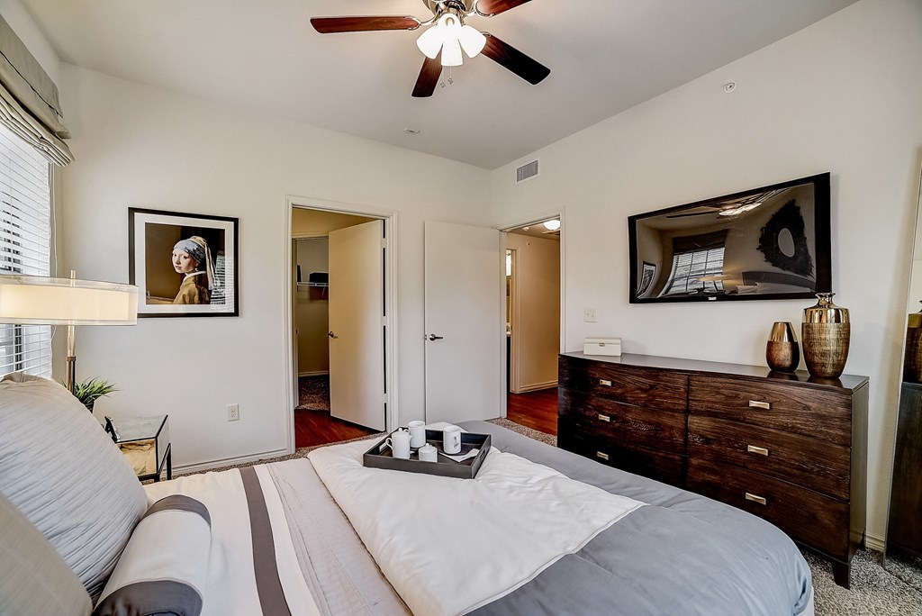 a bedroom with a large bed and a ceiling fan