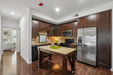 A kitchen with a table and a fridge.