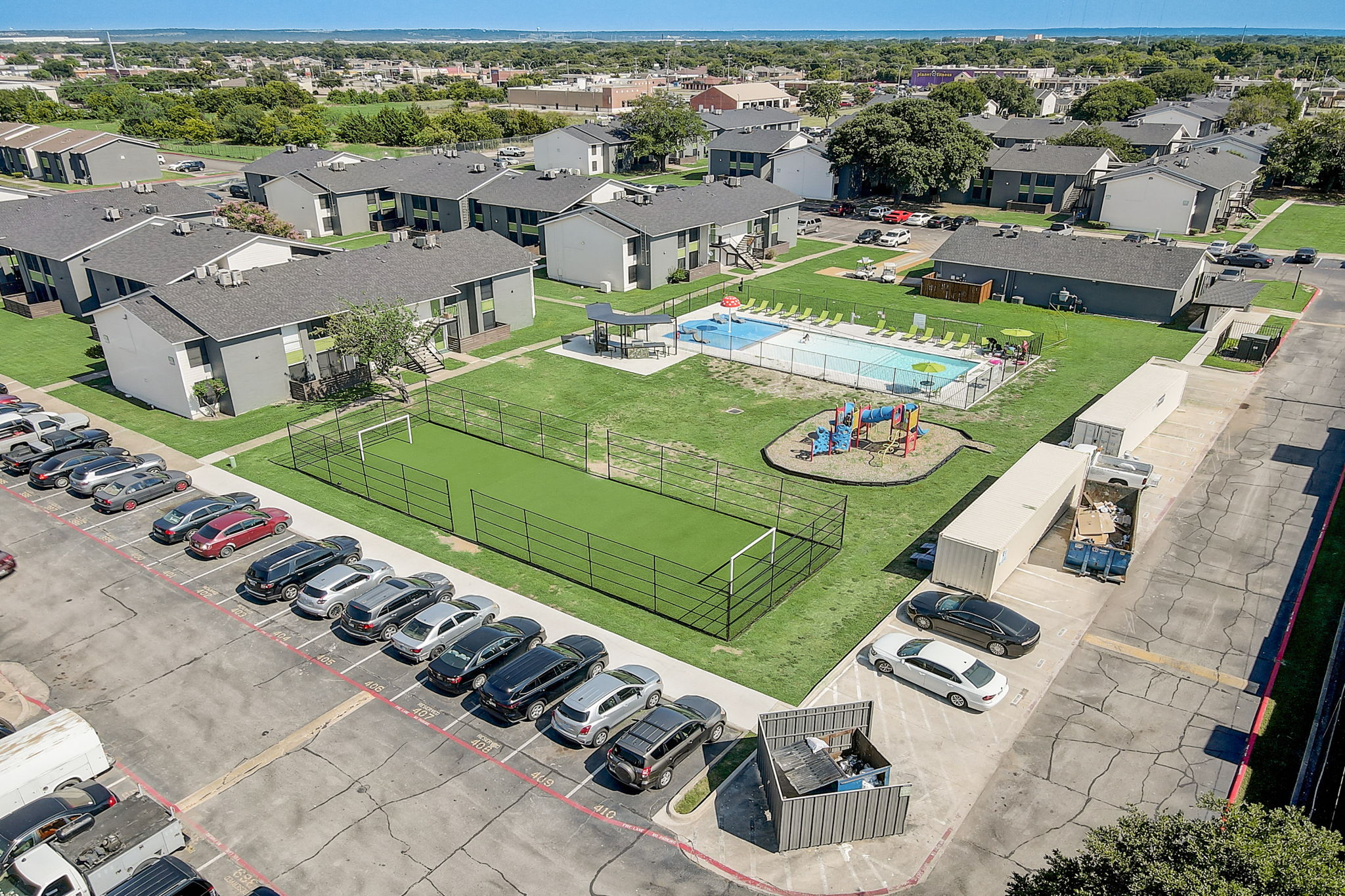 an aerial view of a park with a tennis court and a pool