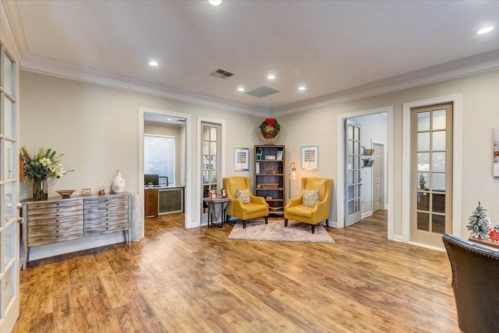 a living room with yellow chairs and a wood floor