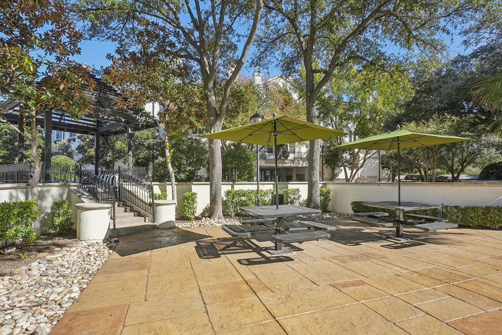 A patio with a table and chairs under umbrellas.