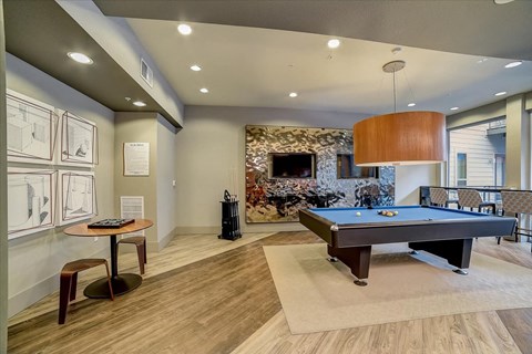 A room with a pool table and a fireplace.