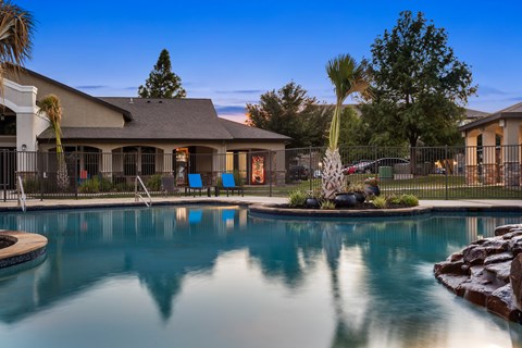 Resort-style pool at The Bradford in Buda, TX with twilight reflections and palms.