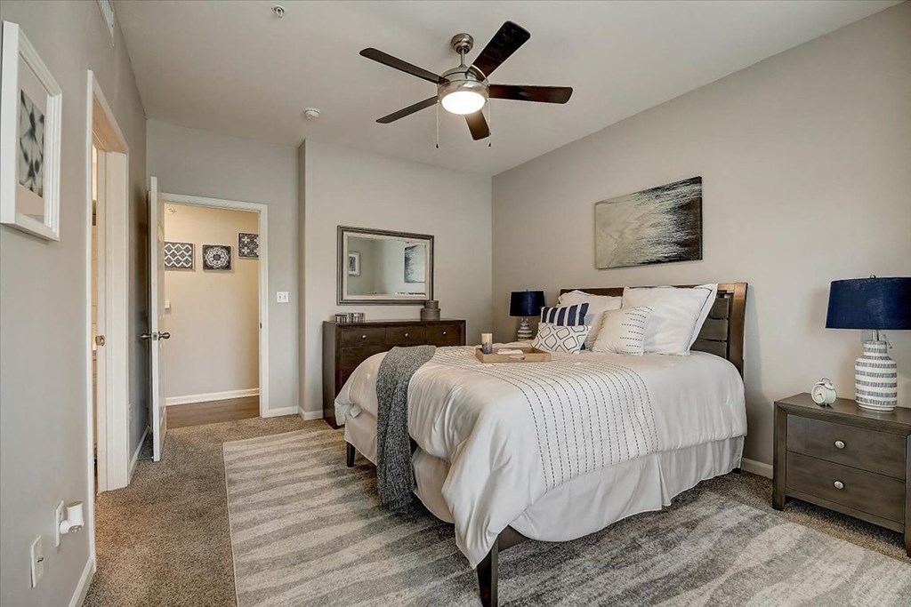 a bedroom with a bed and a ceiling fan