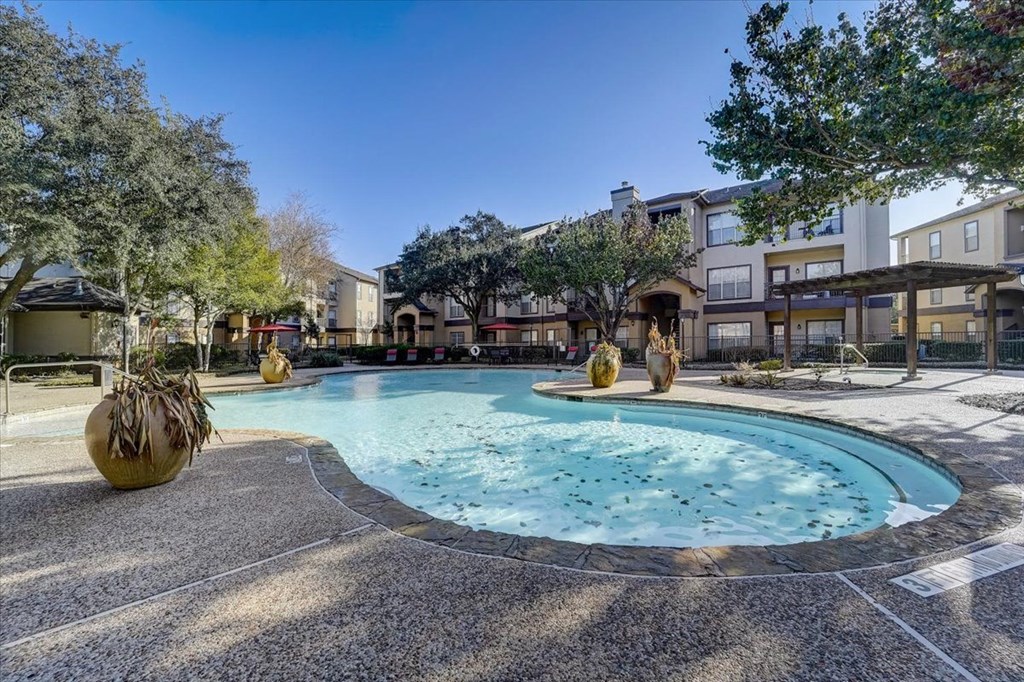 a swimming pool with trees and buildings in the background
