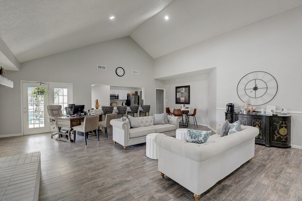 an open living room with couches and a dining room with a table and chairs