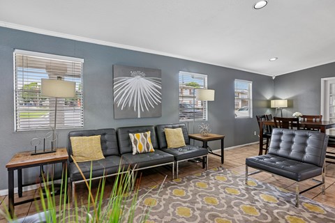 A living room with a grey couch and a yellow pillow.