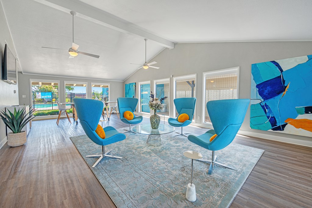 a living room with blue chairs and a glass table