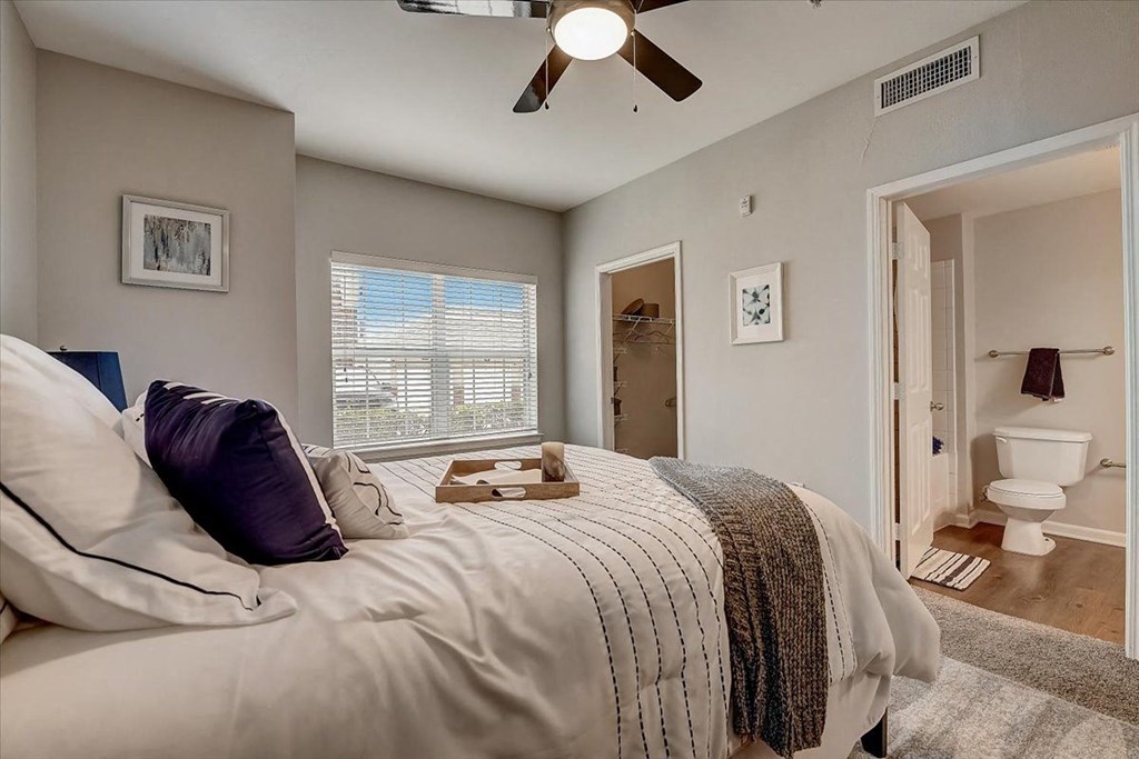 a bedroom with a bed and a ceiling fan