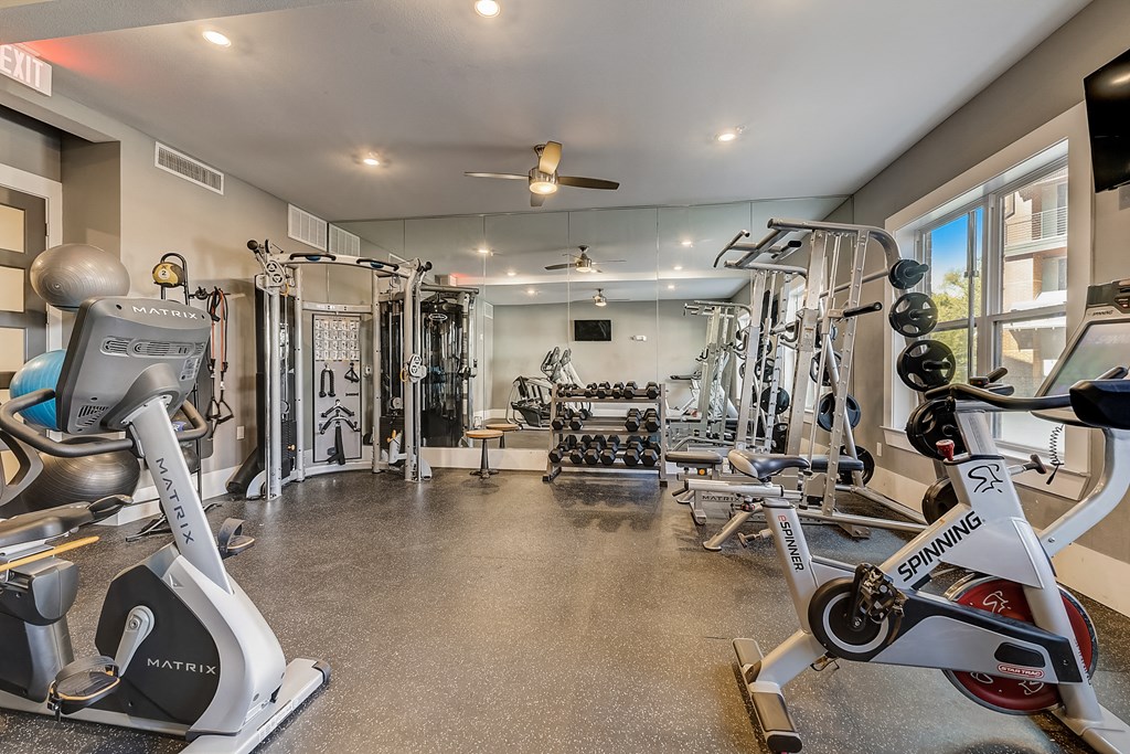 a home gym with exercise equipment and a ceiling fan