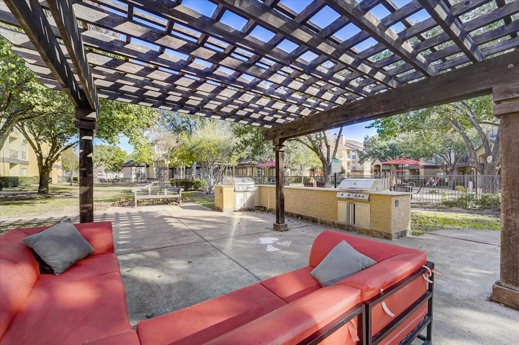a patio with red couches and a pergola