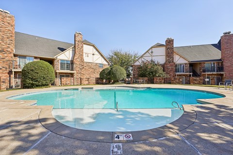 A swimming pool surrounded by a brick building.