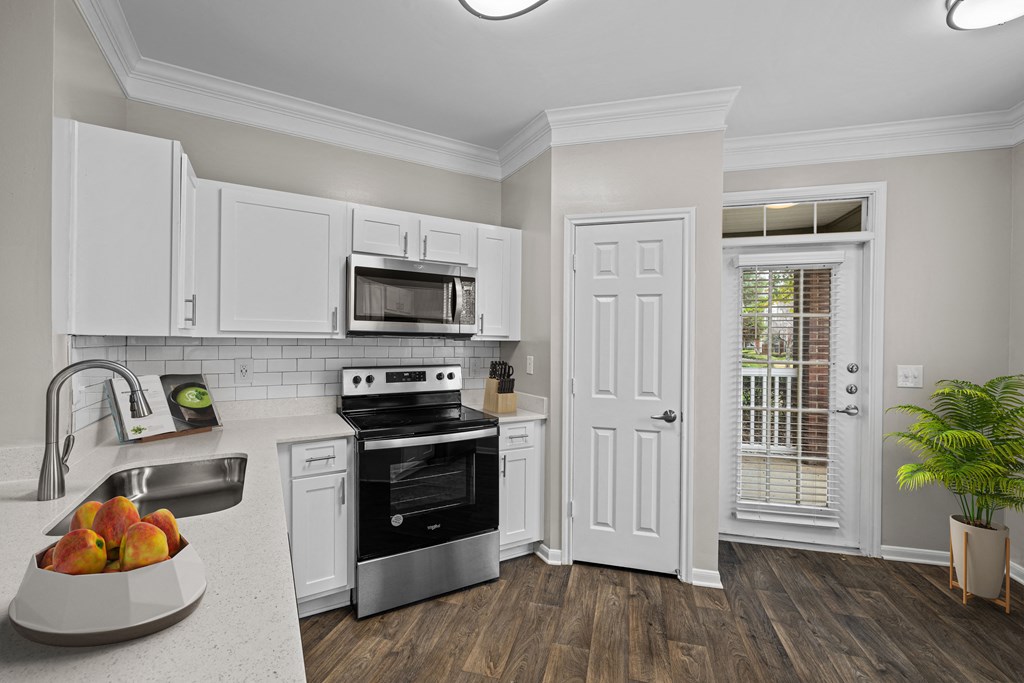 a kitchen with white cabinets and black appliances and a sink