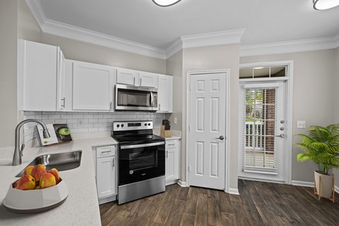 a kitchen with white cabinets and black appliances and a sink