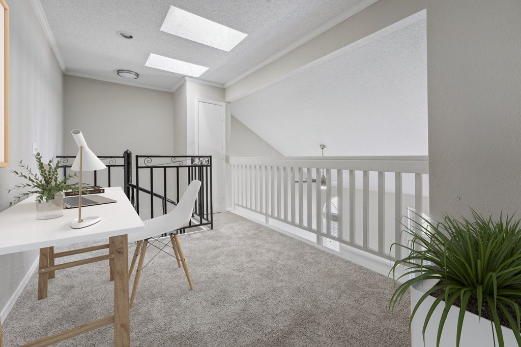 a home office with a white desk and a balcony