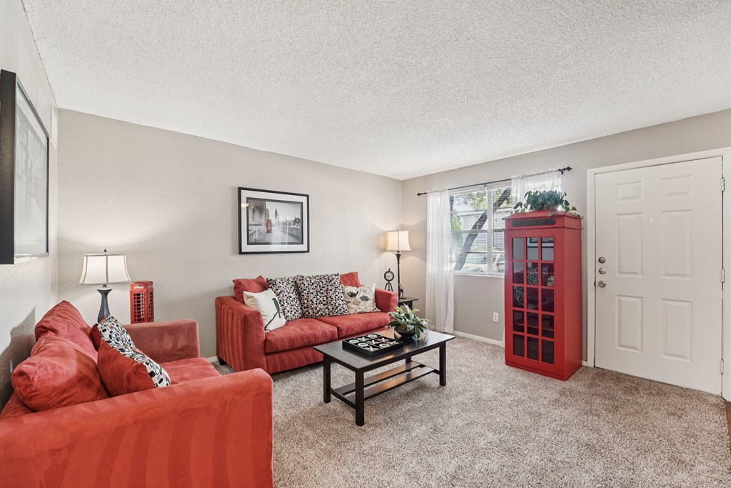 A living room with red couches and a white door.
