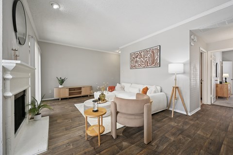 A living room with a white couch, a fireplace, and a painting on the wall.