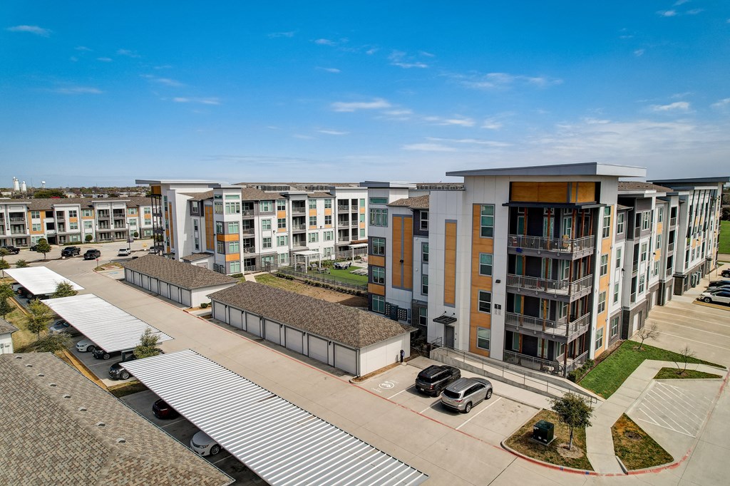an aerial view of an apartment complex with cars parked in front of it