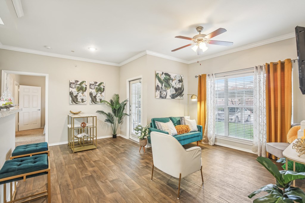 A living room with a white chair, a blue couch, and a television.