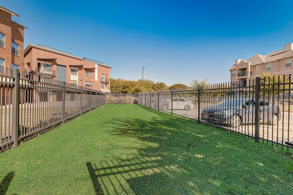 the yard is fenced off with a wrought iron fence