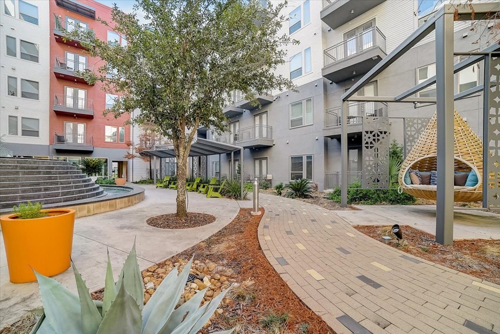 a courtyard with a tree in the middle of an apartment building