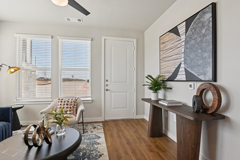 A living room with a brown table and a painting on the wall.