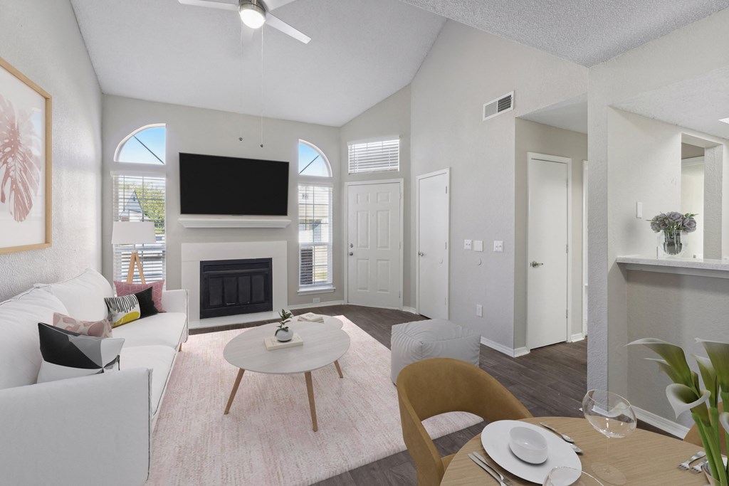 a living room with white furniture and a fireplace
