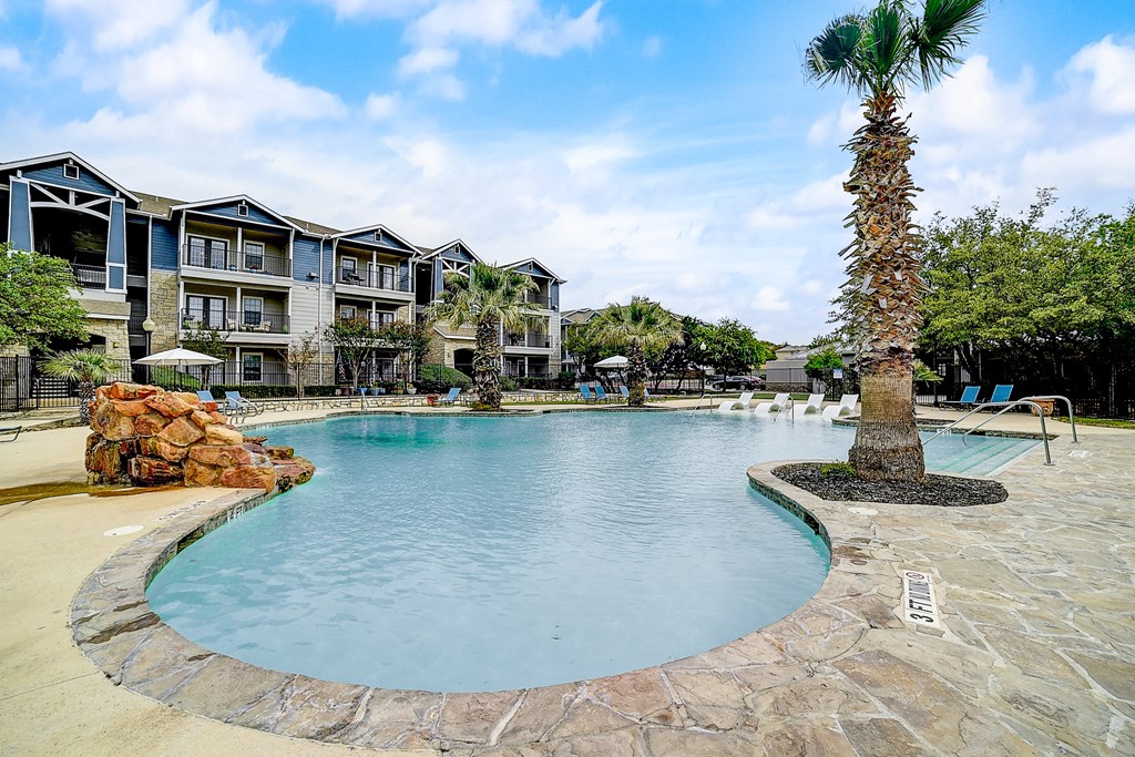 a large swimming pool with a palm tree in the middle of it