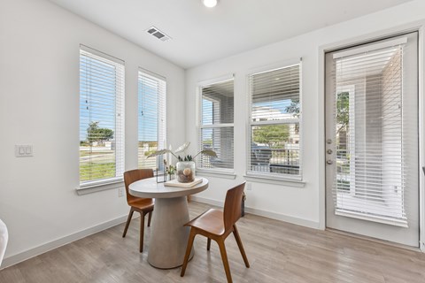 A dining room with a table and chairs.